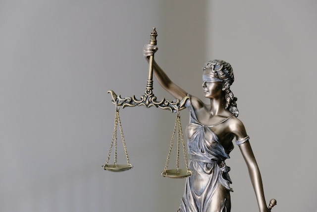 The Right to a Fair Trial as exemplified by Blind lady Justice holding a balanced scale.