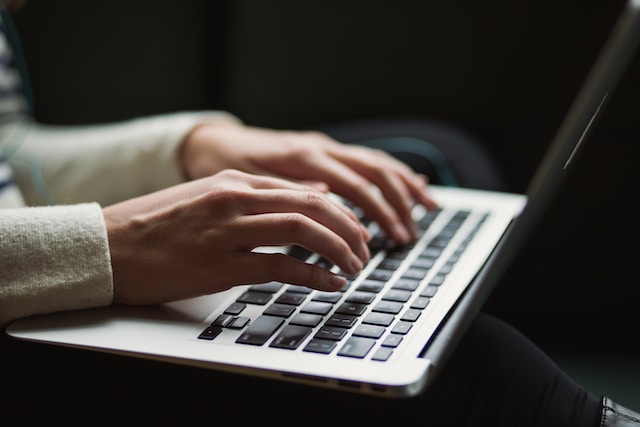 hands typing on a laptop